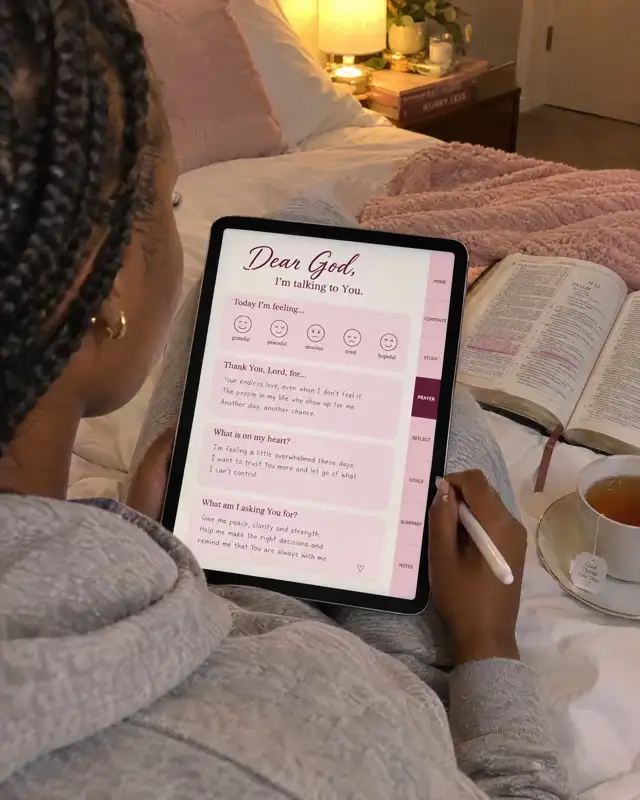 A woman praying through the Dear God page of the digital journal on her iPad in bed